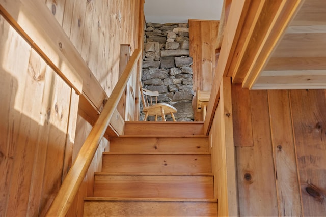 stairs featuring wooden walls