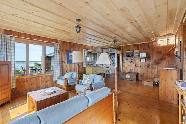 living room featuring a water view, hardwood / wood-style floors, and wood walls