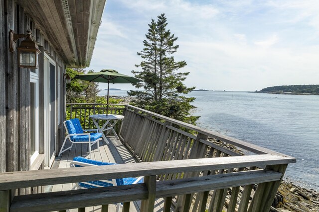 wooden terrace featuring a water view