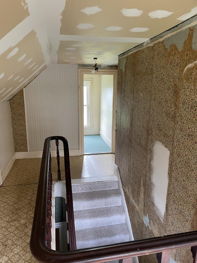 staircase featuring ceiling fan and lofted ceiling