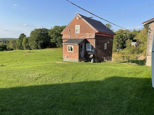 back of property featuring a yard and an outbuilding