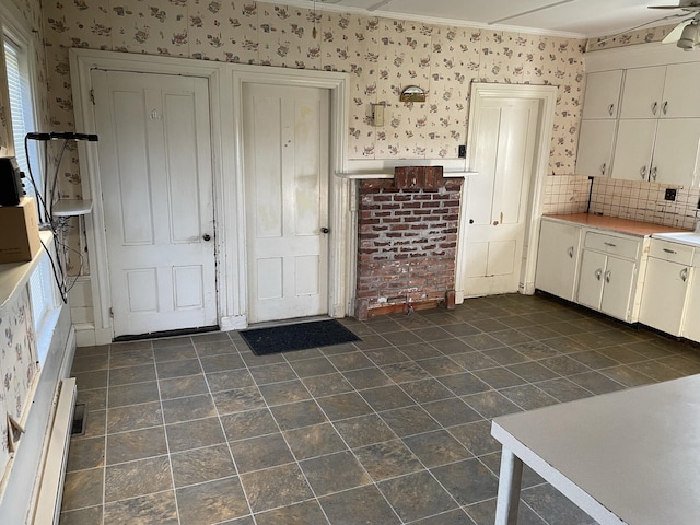 kitchen with ceiling fan, crown molding, tasteful backsplash, and white cabinetry