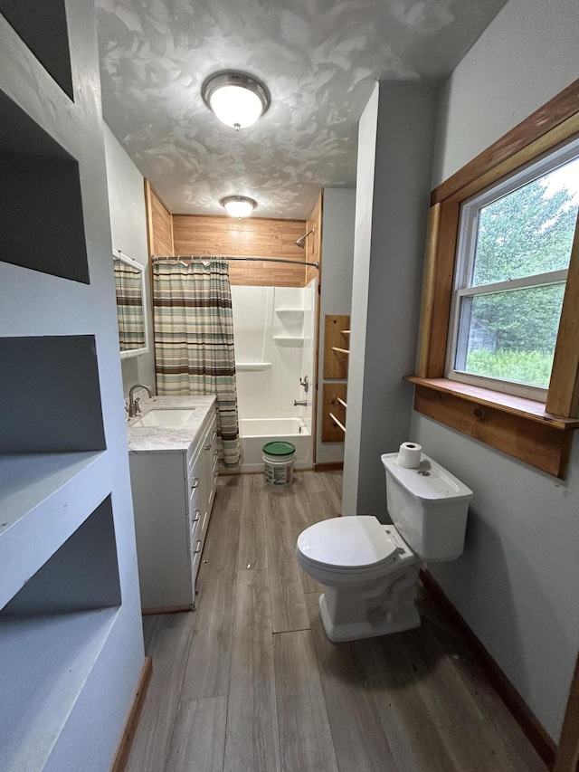 full bathroom featuring toilet, shower / bathtub combination with curtain, hardwood / wood-style flooring, and vanity