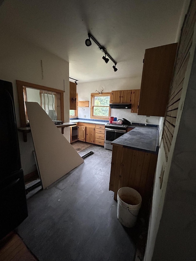 kitchen with kitchen peninsula, black fridge, stainless steel range oven, pendant lighting, and dishwashing machine