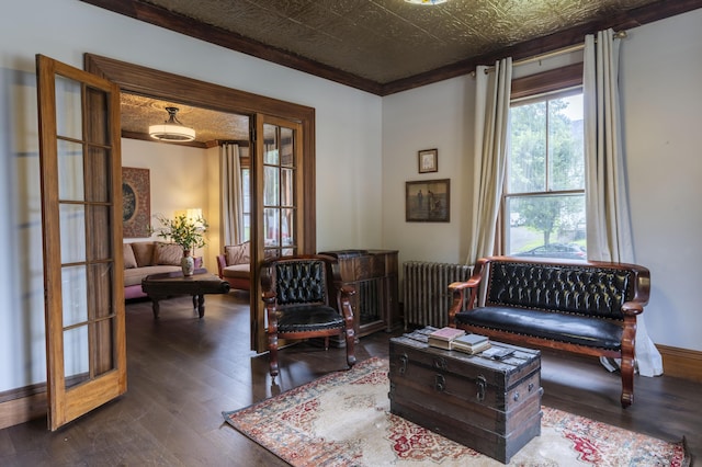 living area with dark wood-type flooring, ornamental molding, french doors, and radiator heating unit