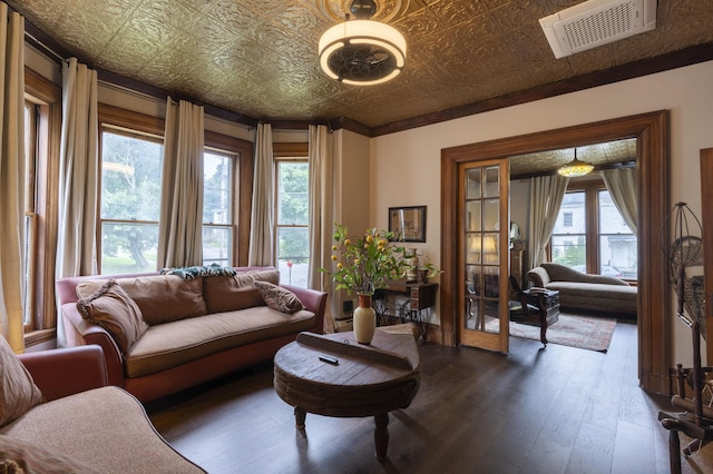 living room with dark wood-type flooring, ornamental molding, a healthy amount of sunlight, and french doors