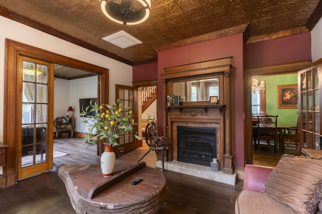 living room featuring dark hardwood / wood-style flooring, crown molding, and french doors