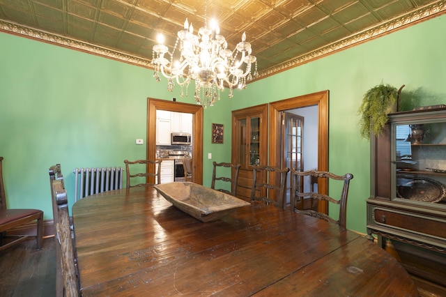 dining area with hardwood / wood-style flooring, radiator, and an inviting chandelier