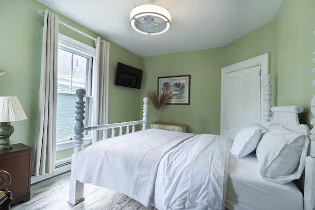 bedroom featuring light hardwood / wood-style flooring and a baseboard radiator