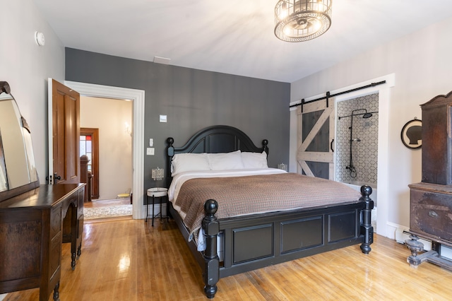 bedroom with hardwood / wood-style floors and a barn door