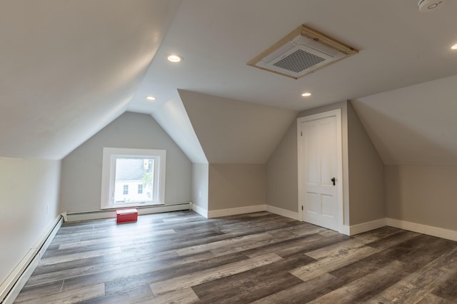 additional living space with lofted ceiling, baseboard heating, and dark hardwood / wood-style flooring