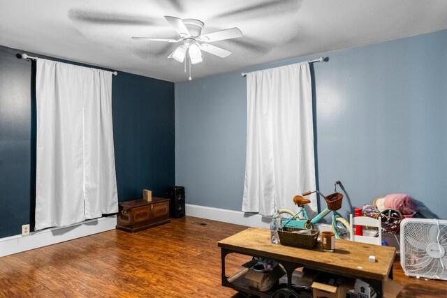 living area featuring ceiling fan, a textured ceiling, and hardwood / wood-style flooring