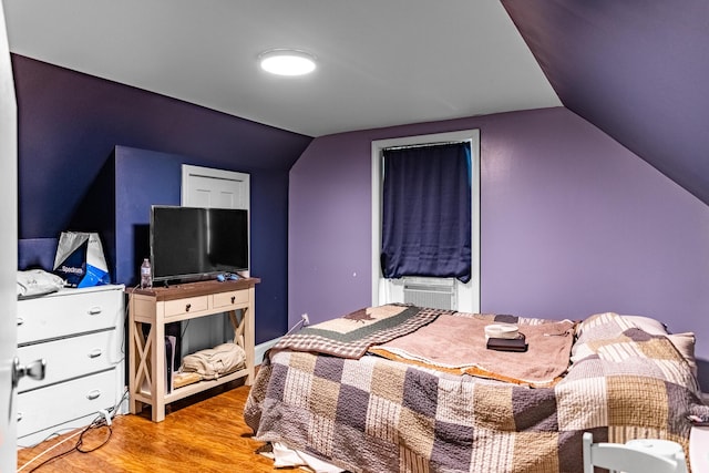 bedroom with lofted ceiling, cooling unit, and light hardwood / wood-style floors