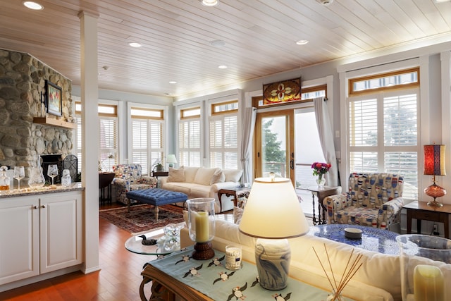 living room featuring light wood-type flooring, wood ceiling, and a fireplace