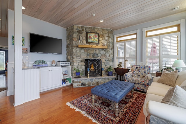 living room featuring wooden ceiling, a fireplace, and light hardwood / wood-style flooring