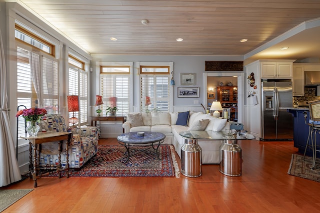 living room featuring light hardwood / wood-style flooring, crown molding, and wood ceiling