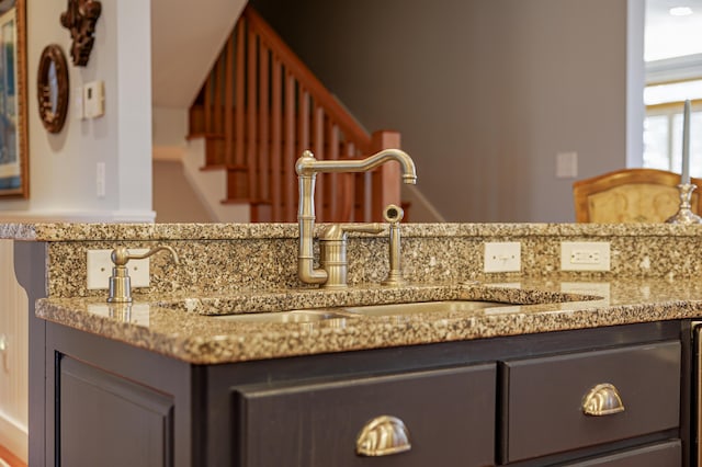 interior space featuring decorative backsplash, light stone countertops, sink, and gray cabinets