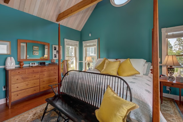 bedroom featuring high vaulted ceiling, multiple windows, hardwood / wood-style floors, and beamed ceiling