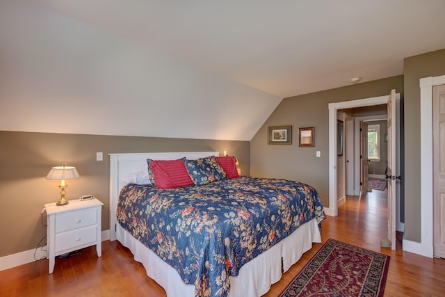 bedroom featuring hardwood / wood-style flooring and lofted ceiling