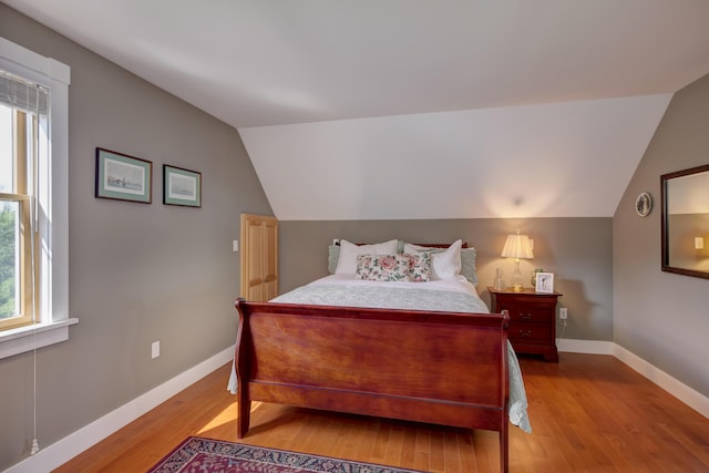 bedroom with light hardwood / wood-style flooring and lofted ceiling