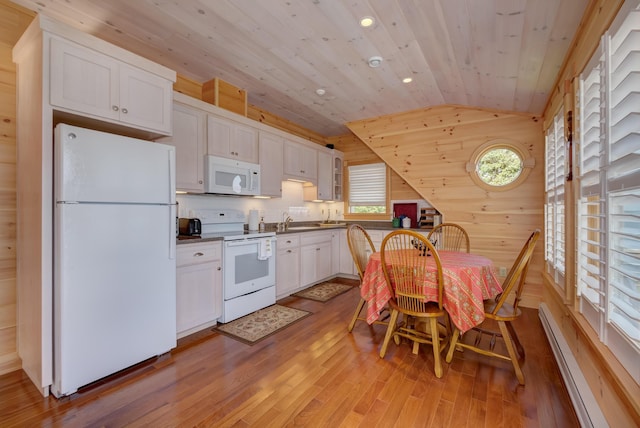 kitchen featuring white cabinetry, light hardwood / wood-style floors, white appliances, baseboard heating, and lofted ceiling