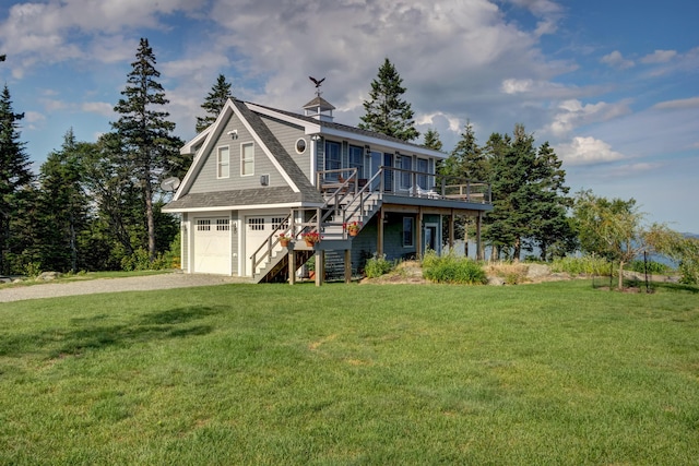 view of front of property with a front yard, a wooden deck, and a garage