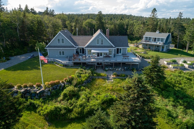 back of house with a deck and a yard