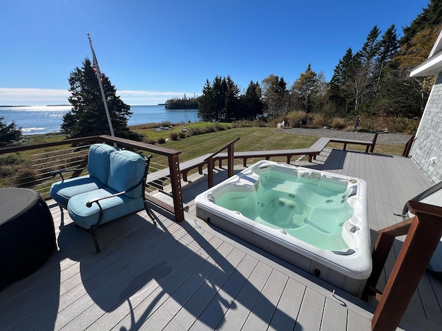 wooden deck with a yard and a water view