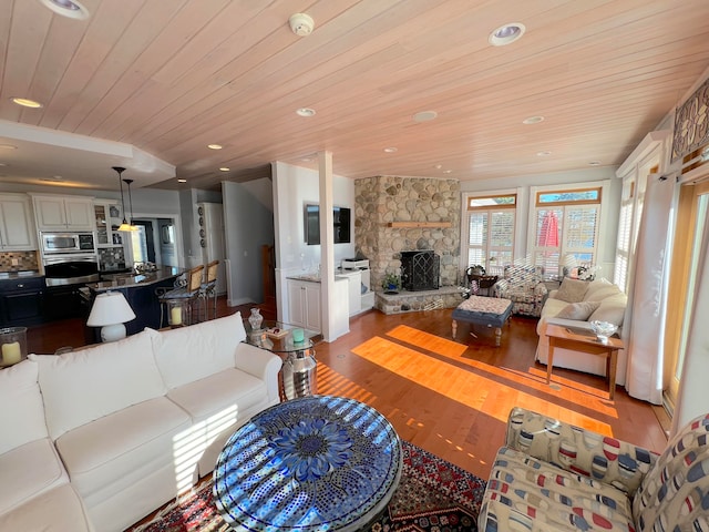 living room featuring light wood-type flooring, wooden ceiling, and a fireplace