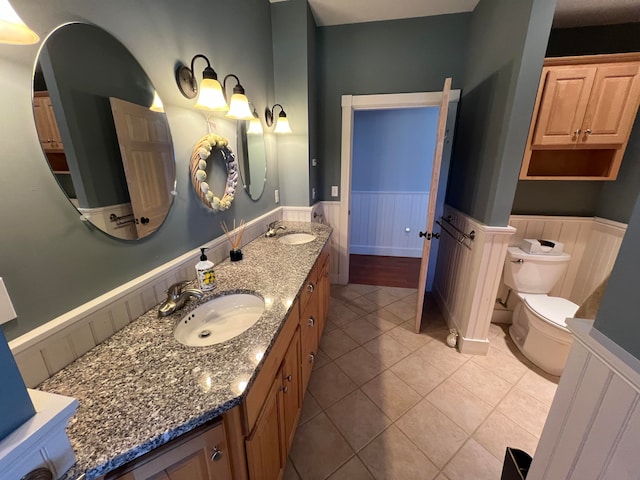 bathroom featuring toilet, tile patterned flooring, and vanity