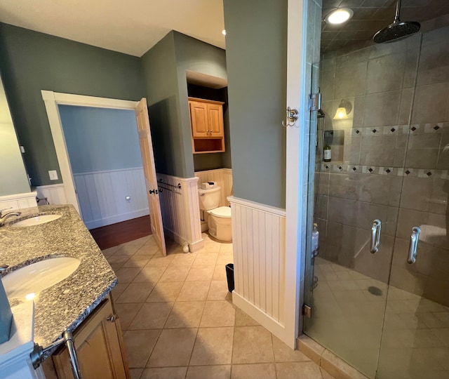 bathroom featuring toilet, vanity, tile patterned flooring, and an enclosed shower