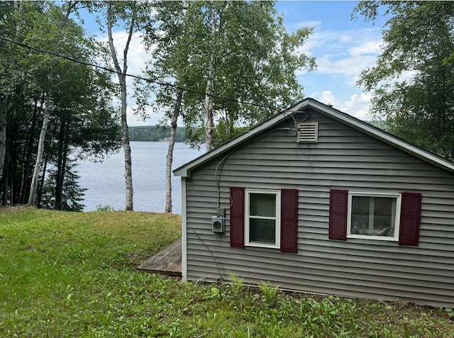 view of side of property featuring a yard and a water view