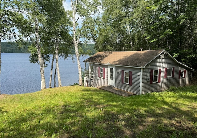 view of front of house with a front lawn and a water view