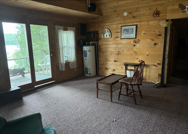 sitting room with water heater, wooden walls, carpet flooring, wooden ceiling, and beam ceiling