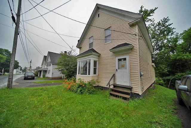 back of property featuring a lawn