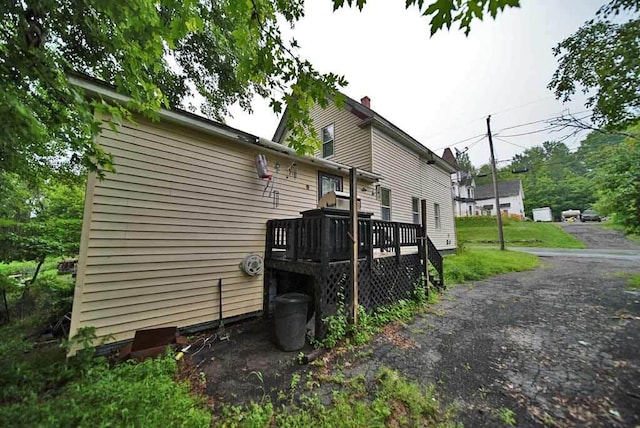 view of property exterior with a wooden deck