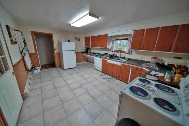 kitchen with washer / dryer, sink, wooden walls, and white appliances