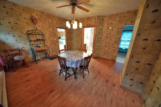 unfurnished dining area with baseboard heating, light hardwood / wood-style floors, and ceiling fan with notable chandelier