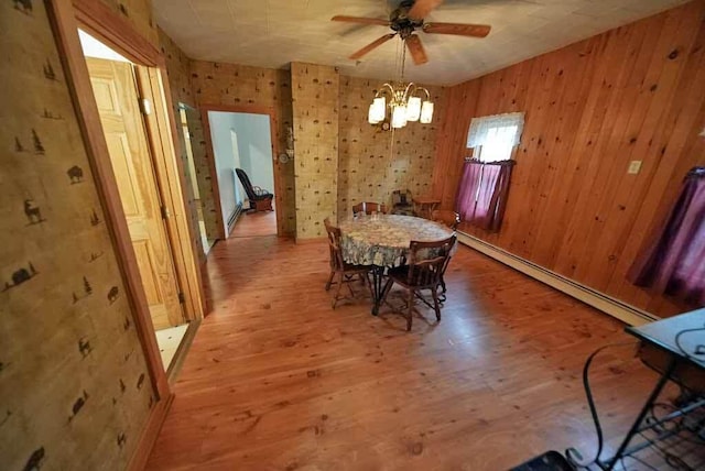 unfurnished dining area with light hardwood / wood-style floors, a baseboard heating unit, and ceiling fan with notable chandelier