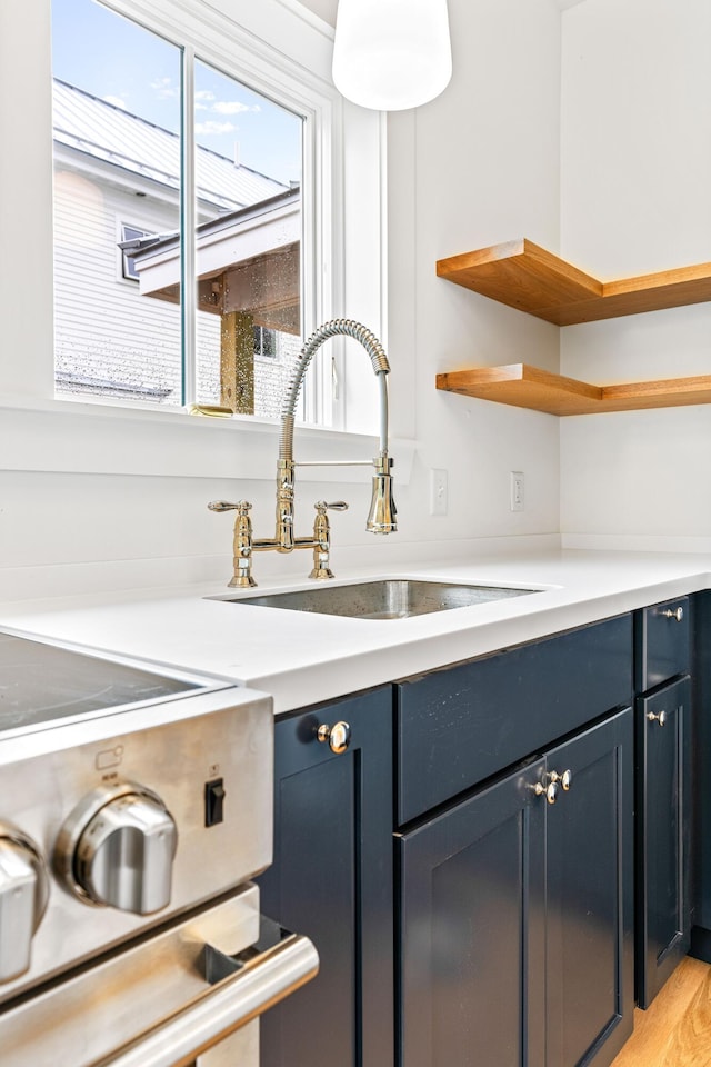 kitchen featuring sink, light hardwood / wood-style flooring, and blue cabinets