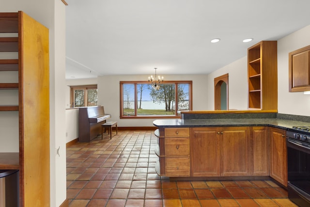 kitchen with kitchen peninsula, black stove, dark tile patterned flooring, and a chandelier