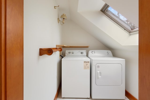 clothes washing area featuring washer and clothes dryer and a skylight