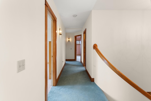 hall with dark colored carpet