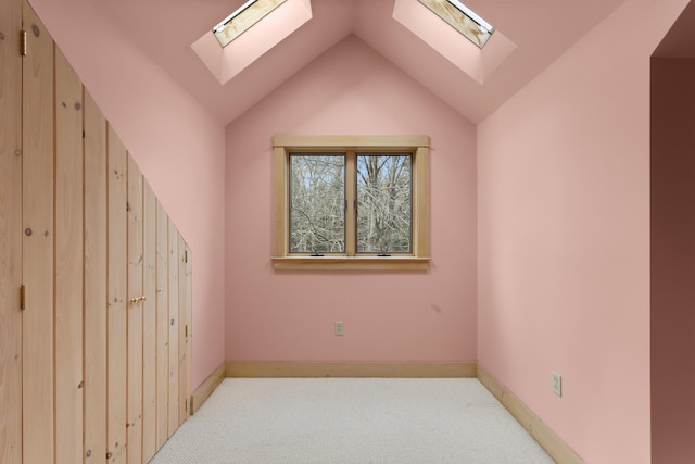 spare room with light colored carpet and lofted ceiling with skylight