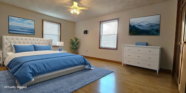 bedroom with ceiling fan and wood-type flooring