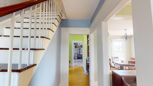 hallway featuring hardwood / wood-style floors and a chandelier