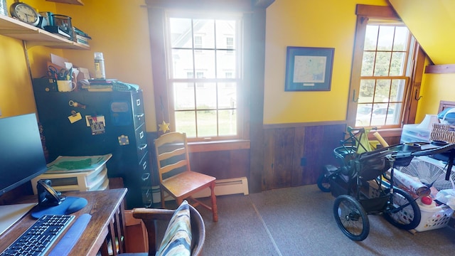 miscellaneous room with a baseboard radiator, wood walls, and a healthy amount of sunlight