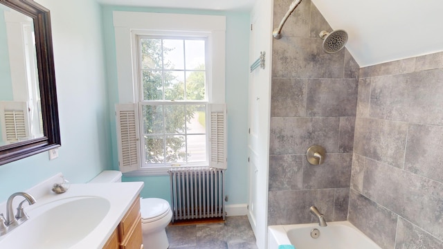 full bathroom featuring radiator, lofted ceiling, tiled shower / bath, vanity, and toilet