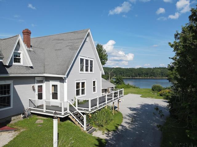 back of house featuring a deck with water view and a yard