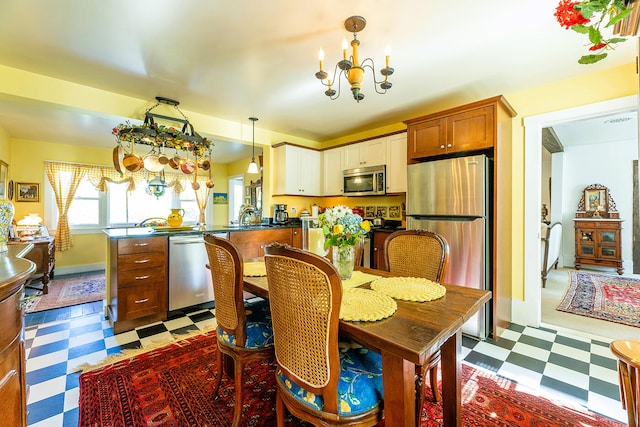 tiled dining room featuring sink and an inviting chandelier